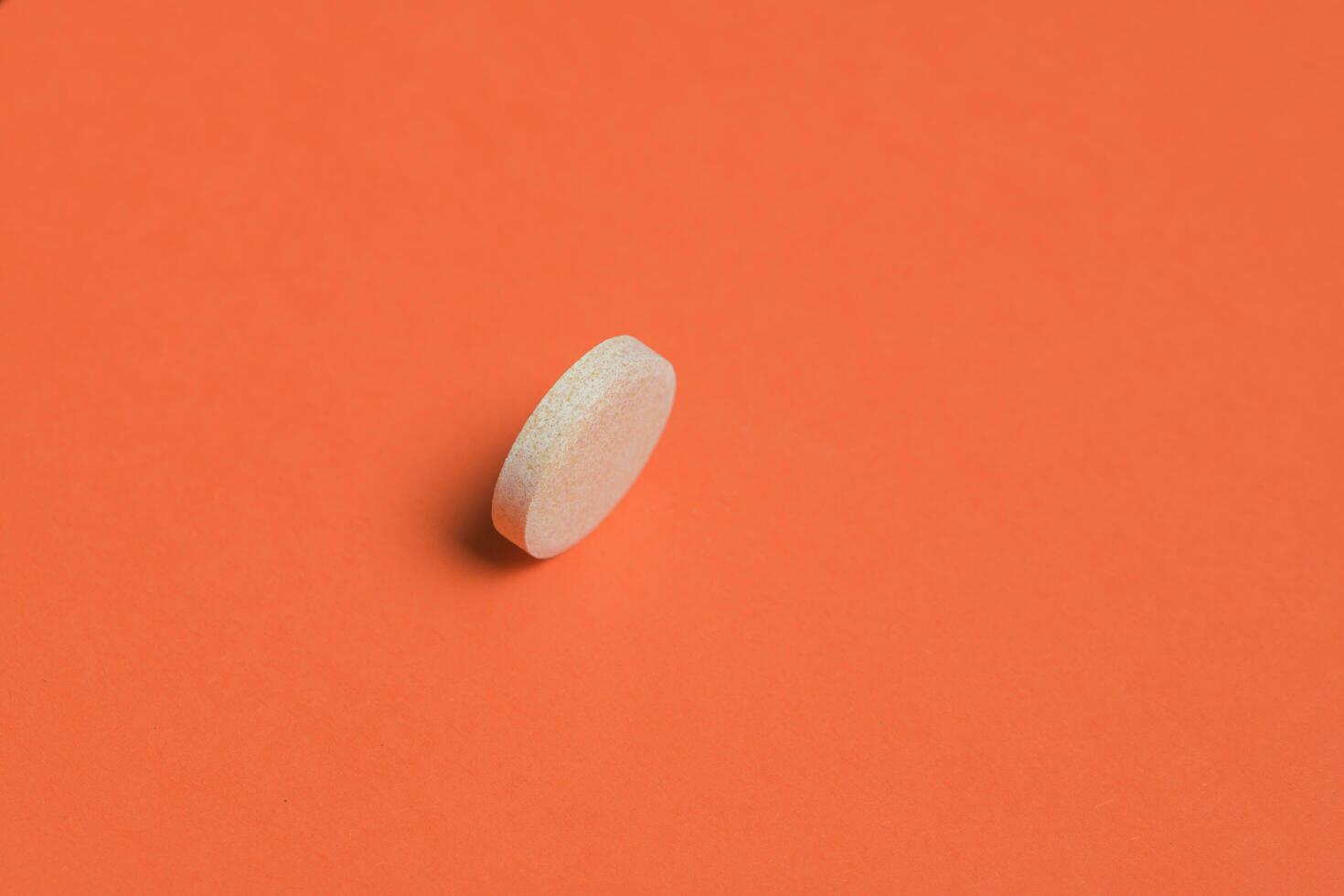 Effervescent tablet isolated on orange background photo