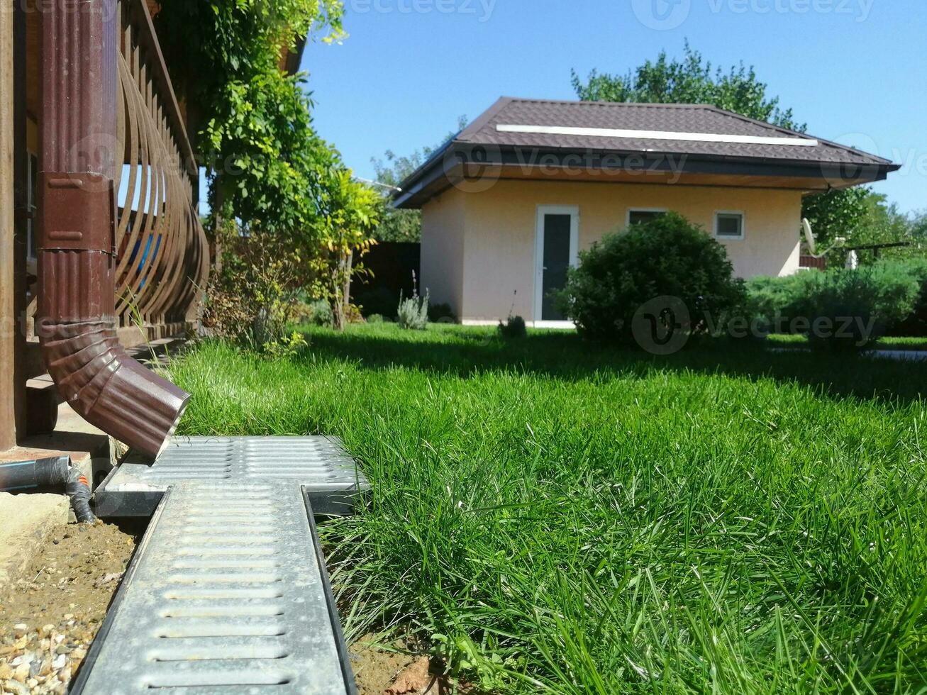 drainage systems. metal structure from the roof. sewer and grate on the ground to drain water. photo