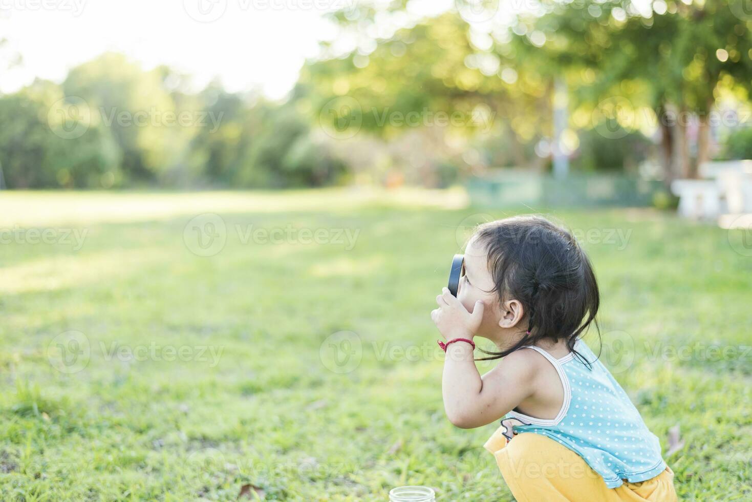 Children explore nature in a sunny summer garden, scout club and outdoor science classroom. Young woman using a magnifying glass to explore the surroundings The adventures of a young explorer. photo