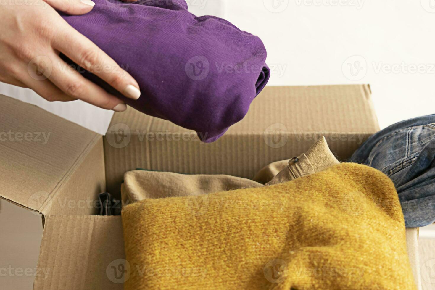 Woman packs clothes in boxes for donating. photo