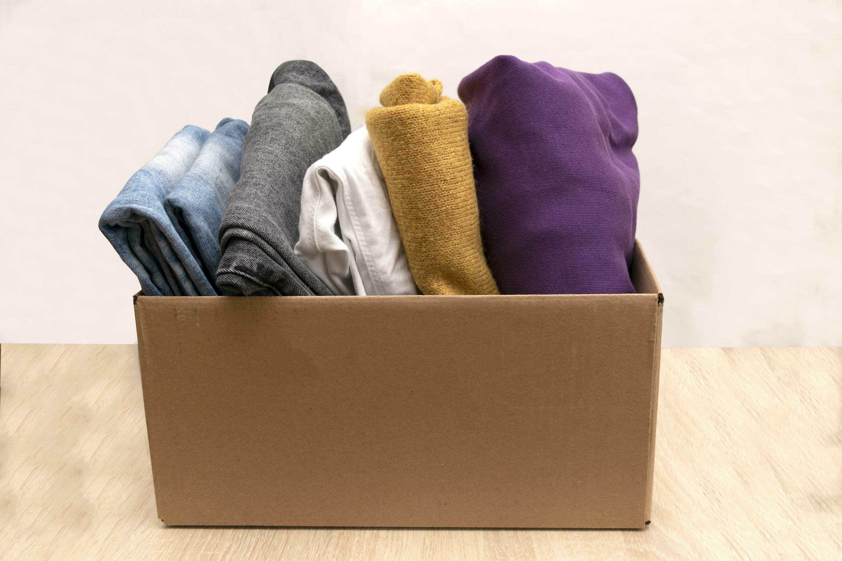 Woman packs clothes in boxes for donating. 23746063 Stock Photo at Vecteezy