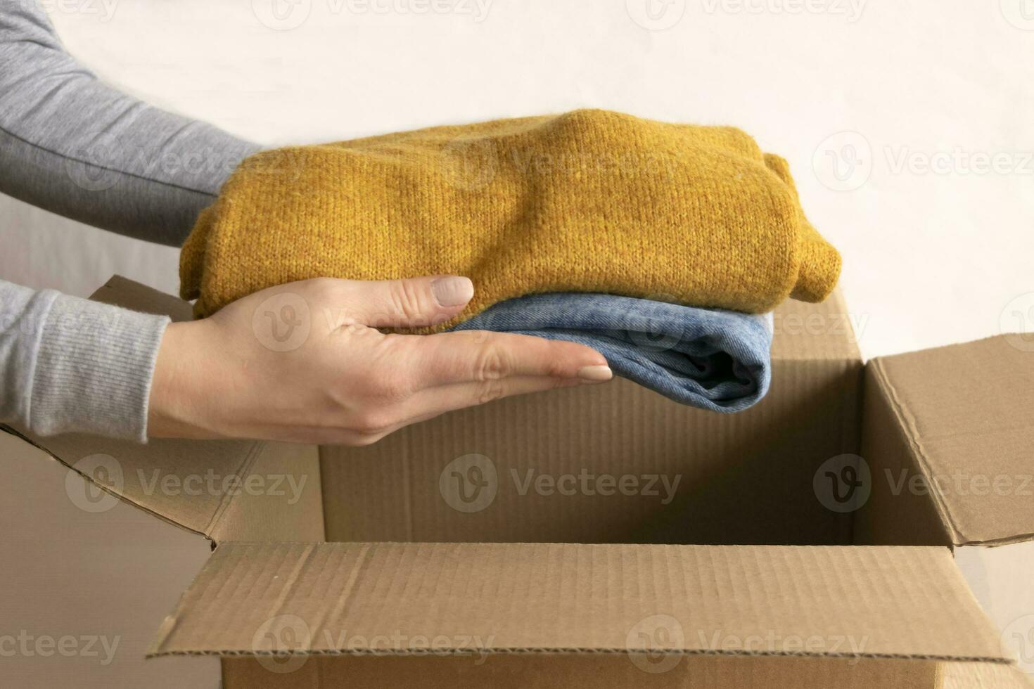 Woman packs clothes in boxes for donating. 23746064 Stock Photo at Vecteezy