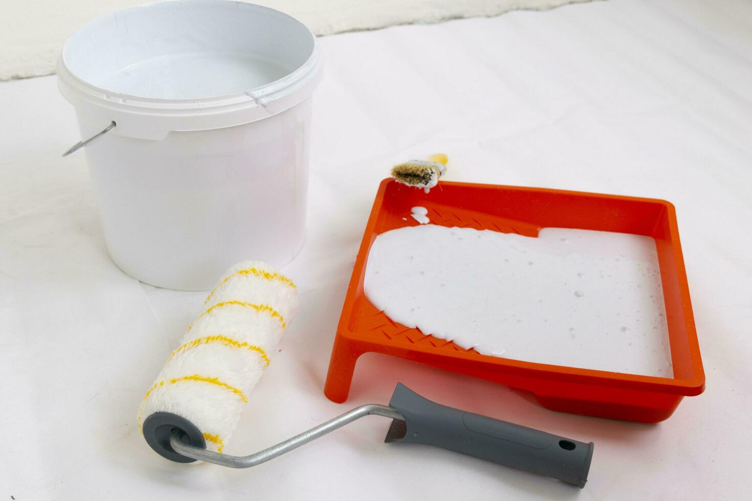 Paint can, roller and paint tray for painting wall on the floor photo