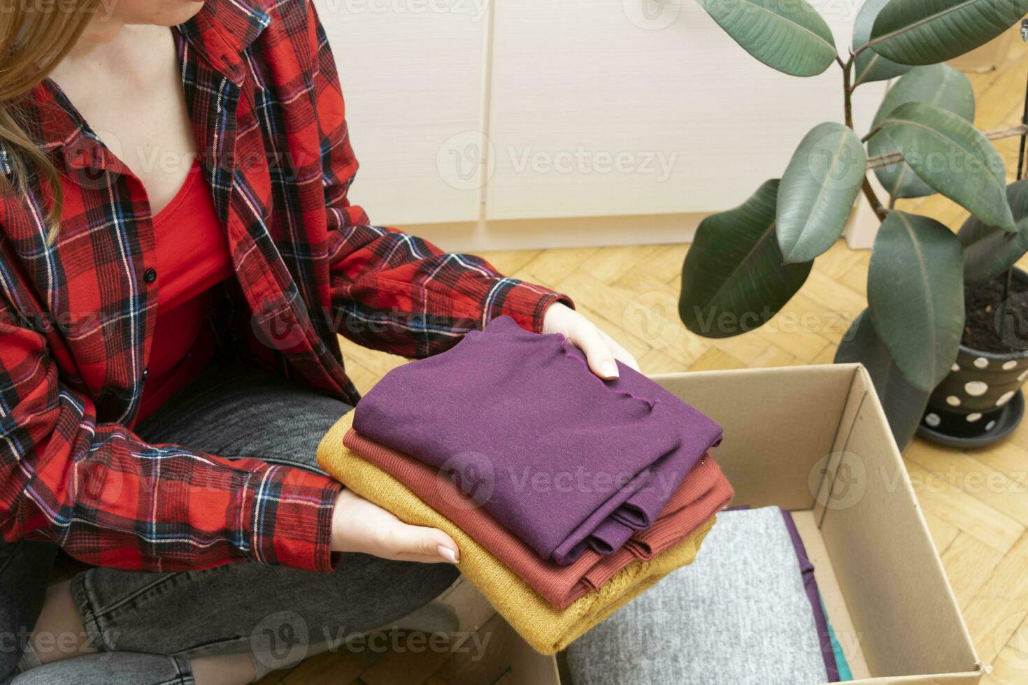 Woman packs clothes in boxes for donating. 23746078 Stock Photo at Vecteezy