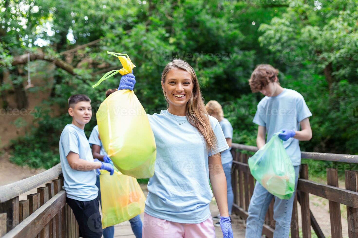 Group of volunteers cleaning up forest from waste, community service concept photo