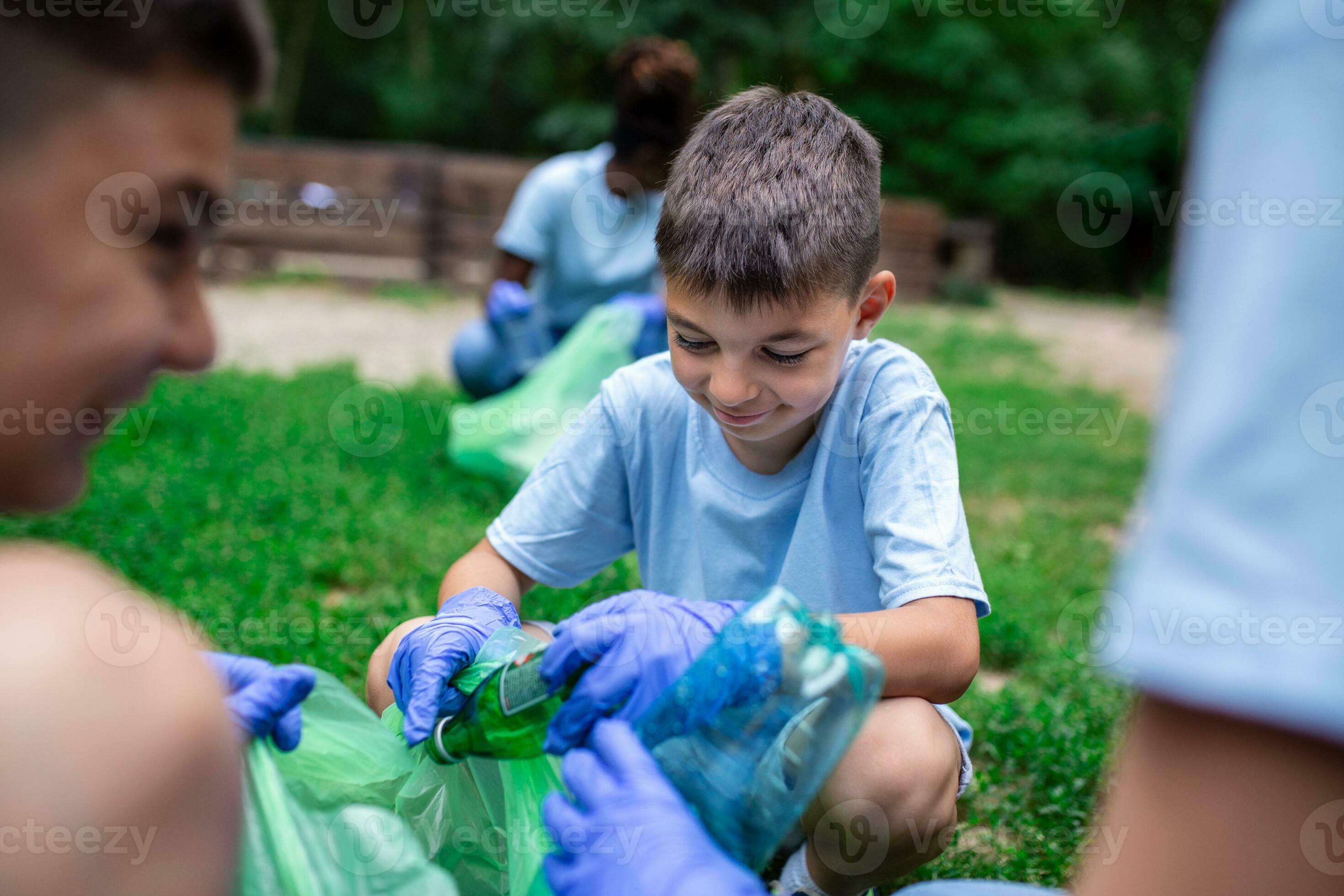 Group of kids volunteers cleaning together a public park. They are
