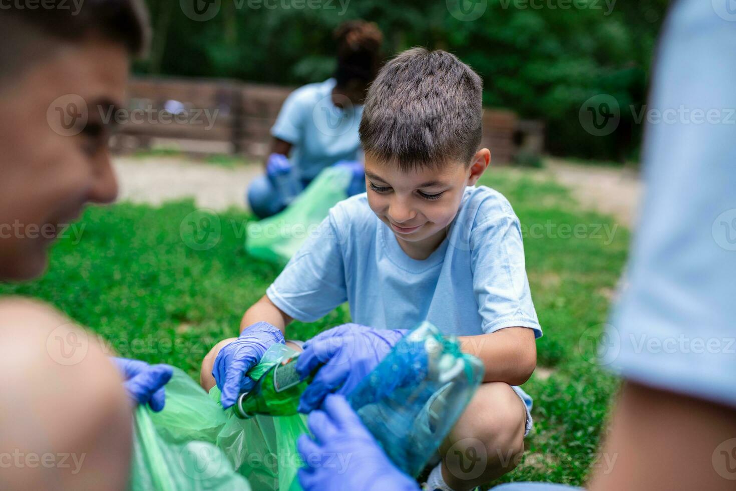 Group of kids volunteers cleaning together a public park. They are picking up garbage. photo