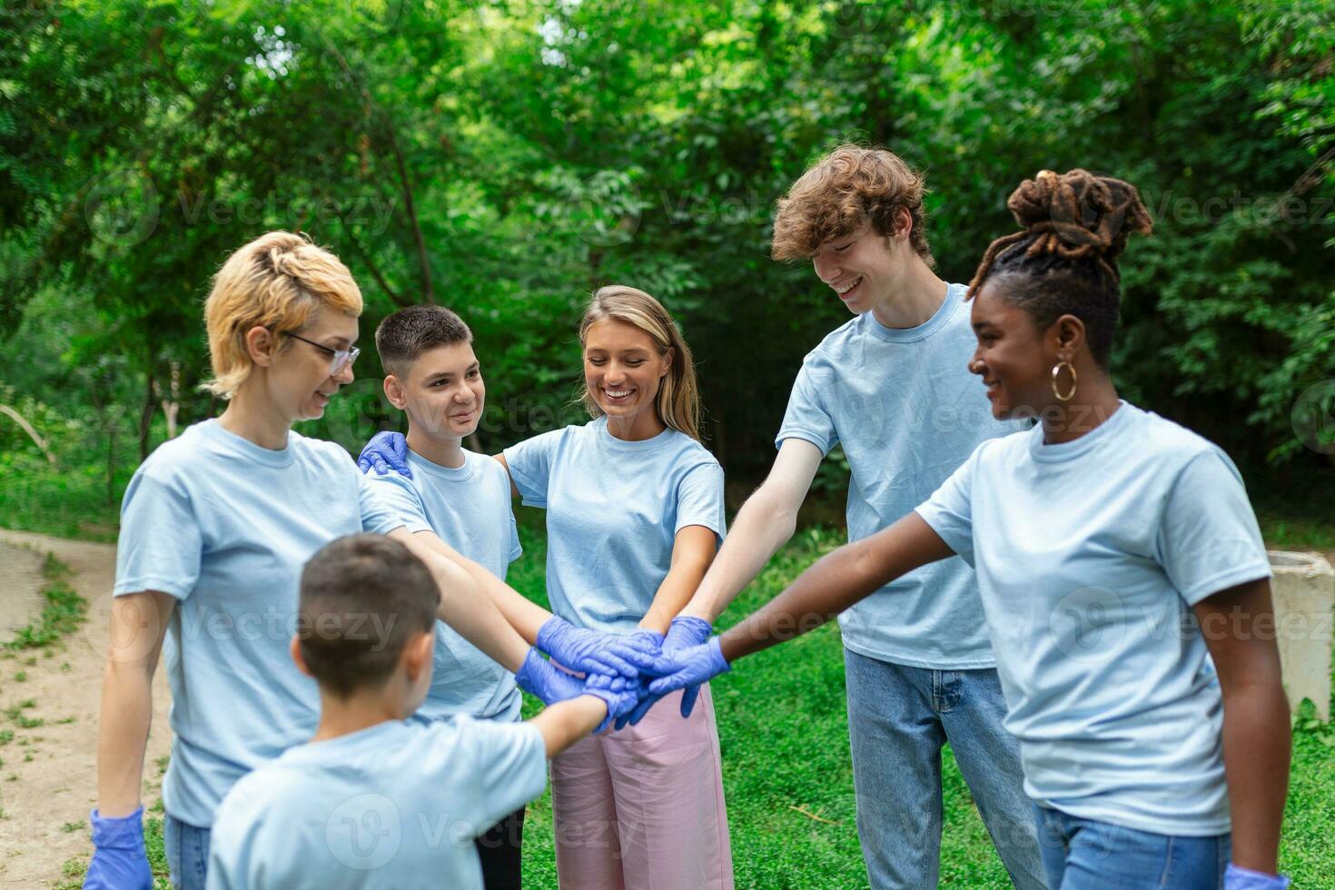 Portrait of volunteers folding their arms. Environmentalists are in a public park. They are in blue T-shirts. The concept of friendship and helping photo