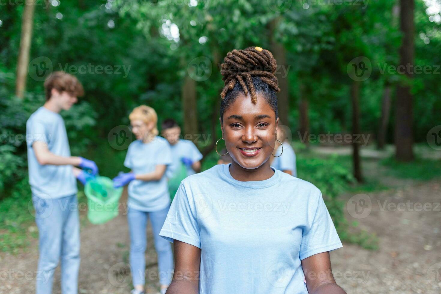 A multiethnic group of people, cleaning together in a public park, are protecting the environment. The concept of recycling and cleaning photo