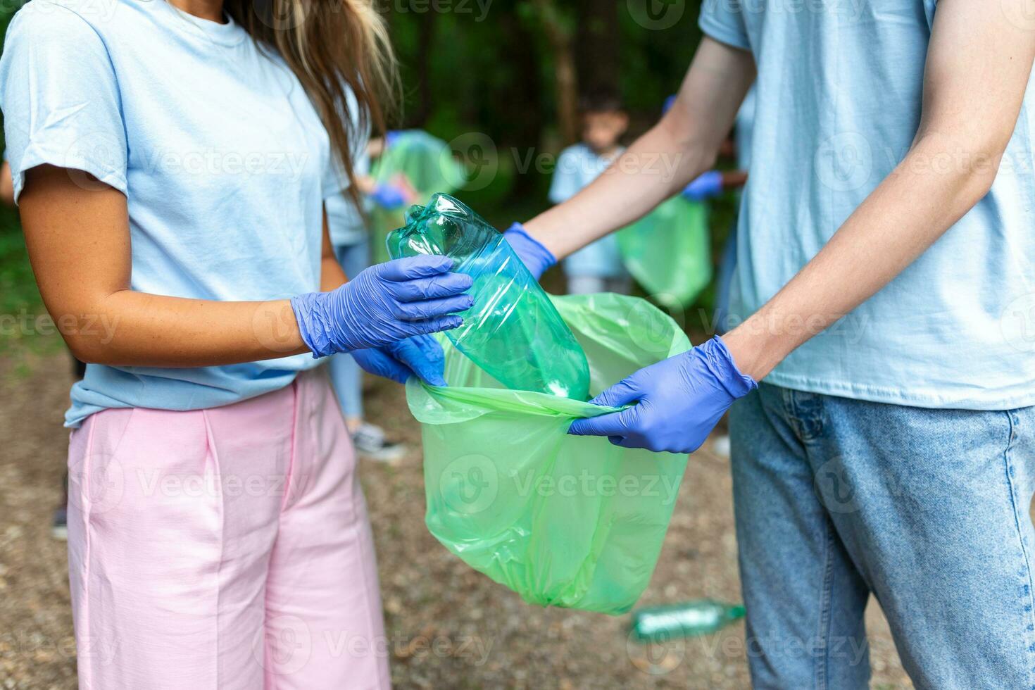 Volunteers is picking up plastic waste at nature. Activists collecting garbage in the park. photo