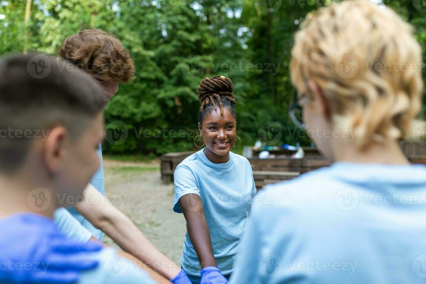 Portrait of volunteers folding their arms. Environmentalists are in a public park. They are in blue T-shirts. The concept of friendship and helping photo