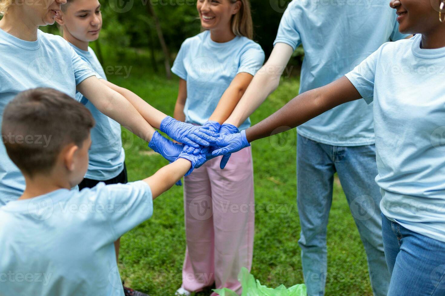 Support concept. Happy volunteers holding hands in circle and smiling, teambuilding exercise, teamwork and help, copy space photo