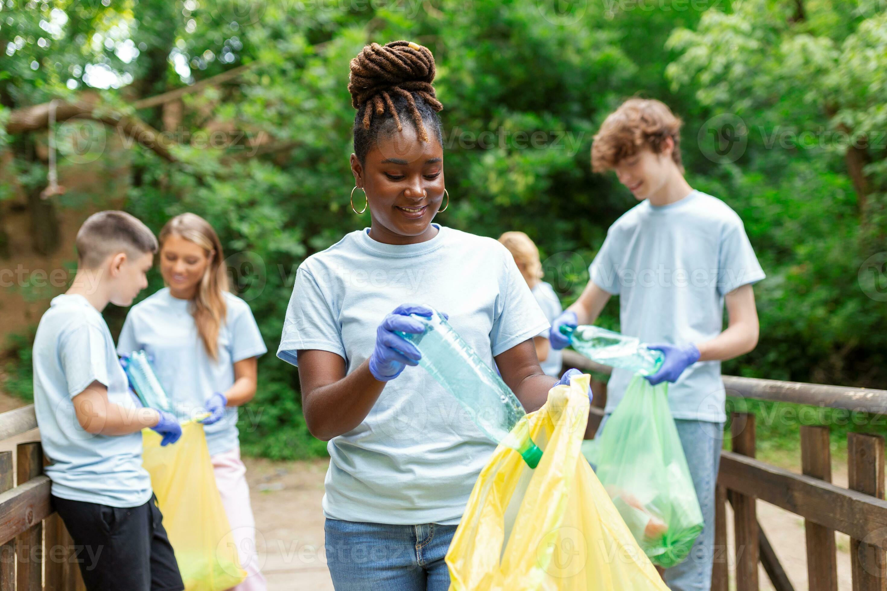 A multiethnic group of people, cleaning together in a public park, are