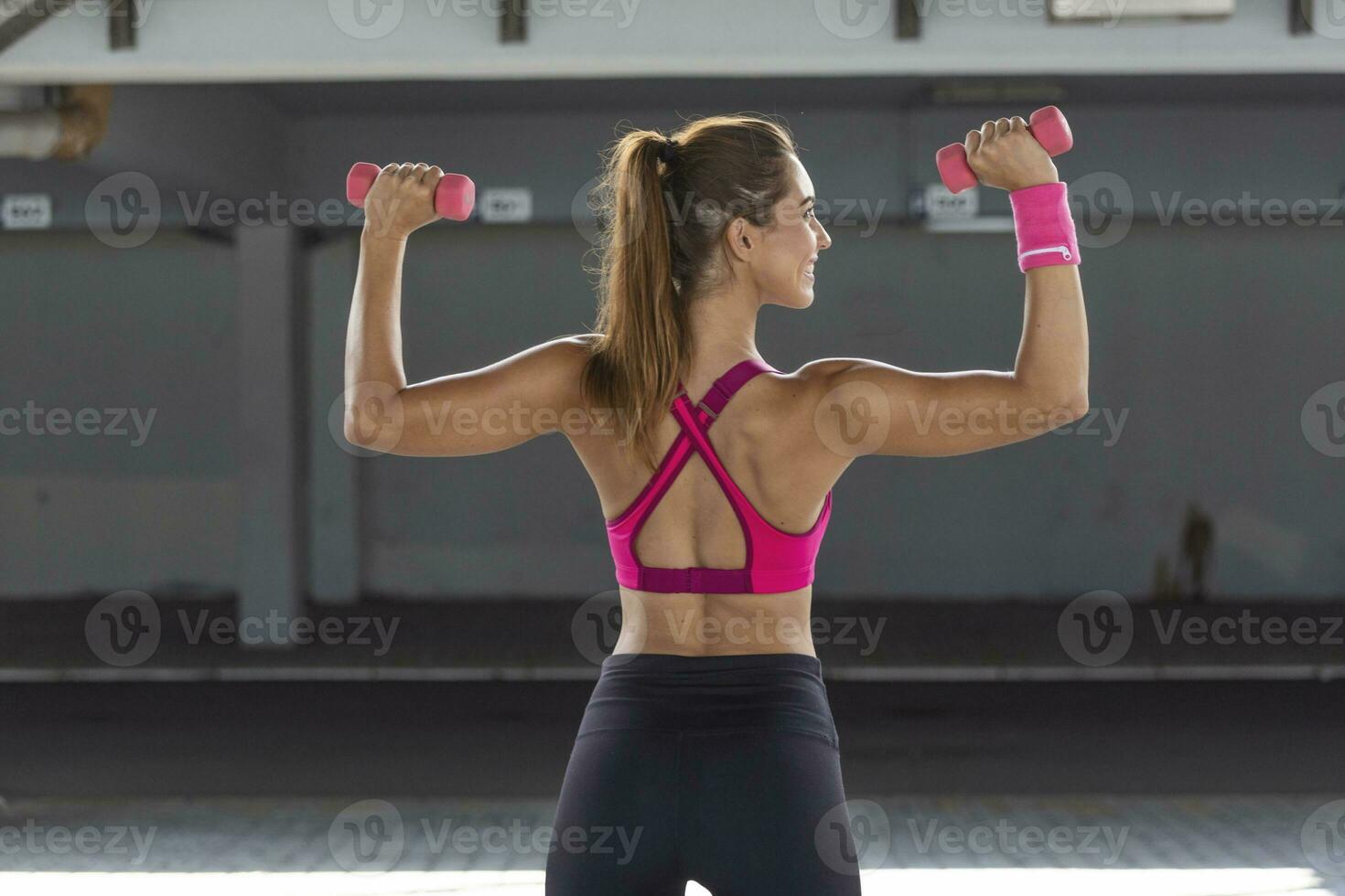 Strong fit woman working out with dumbbells. Attractive fit woman works out with dumbbells as a fitness conceptual. Active woman in sportswear working out. photo