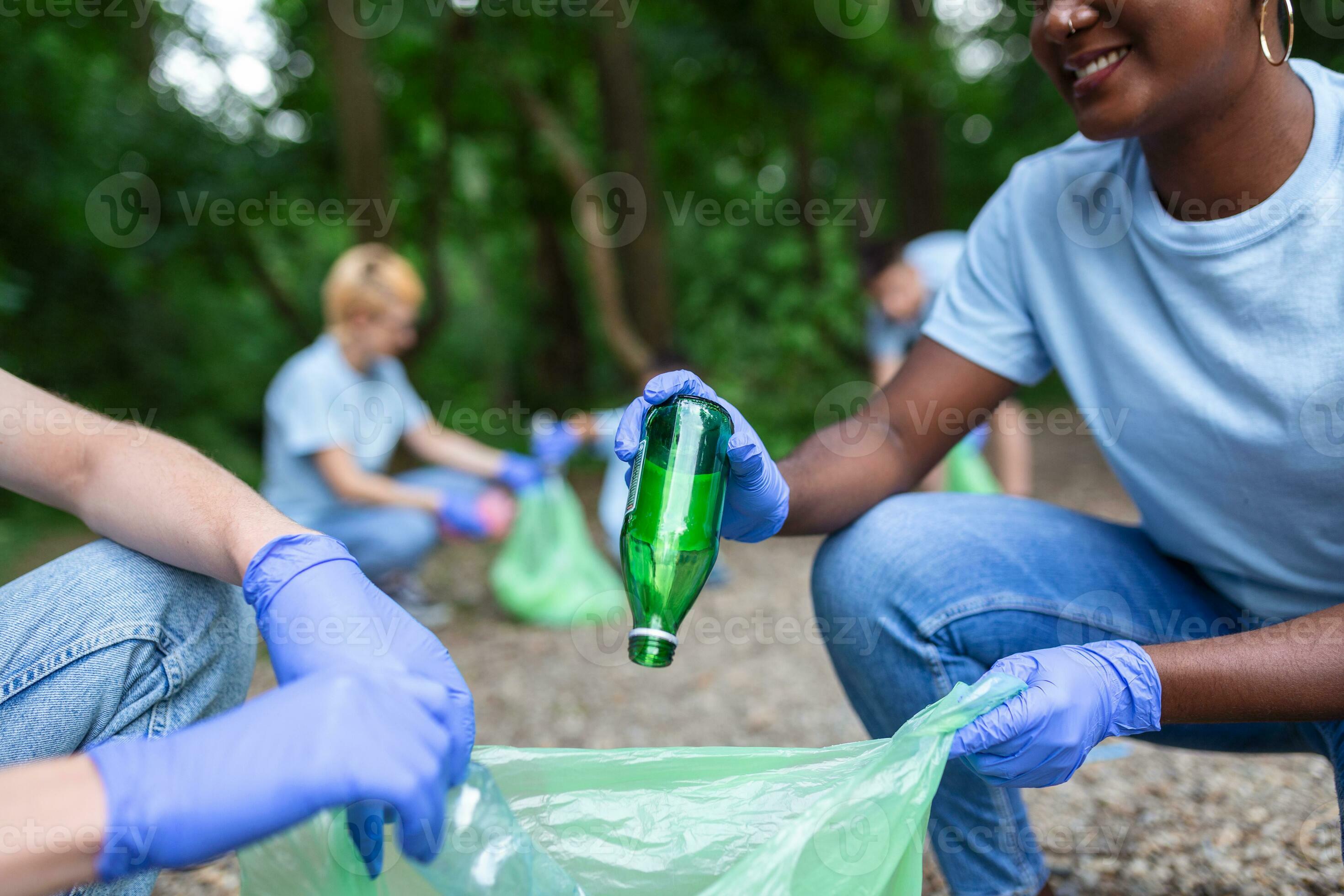 A multiethnic group of people, cleaning together in a public park, are
