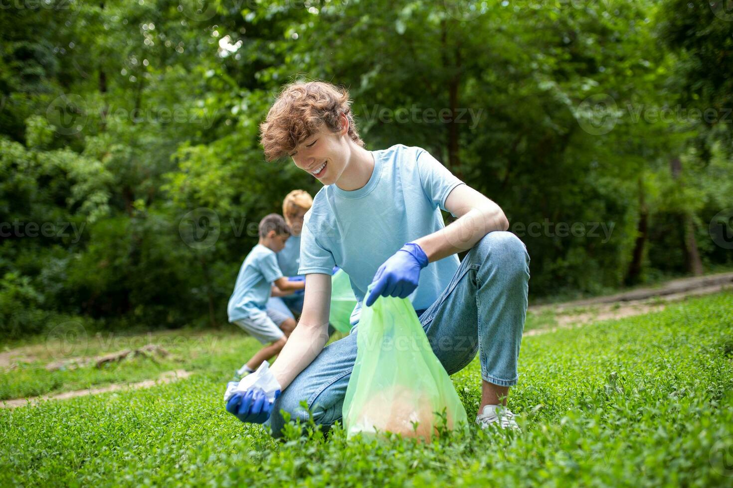 Group of volunteers cleaning up forest from waste, community service concept photo