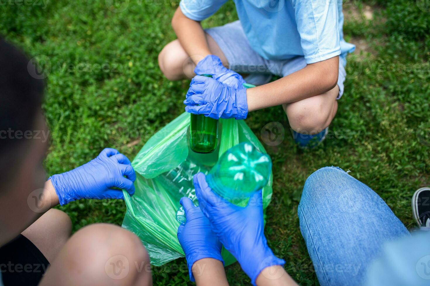 Collecting trash in the local park .Young people is cleaning his local park of the common trash - plastic bottles, bags, cans, cigarette boxes and other recyclable waste. photo