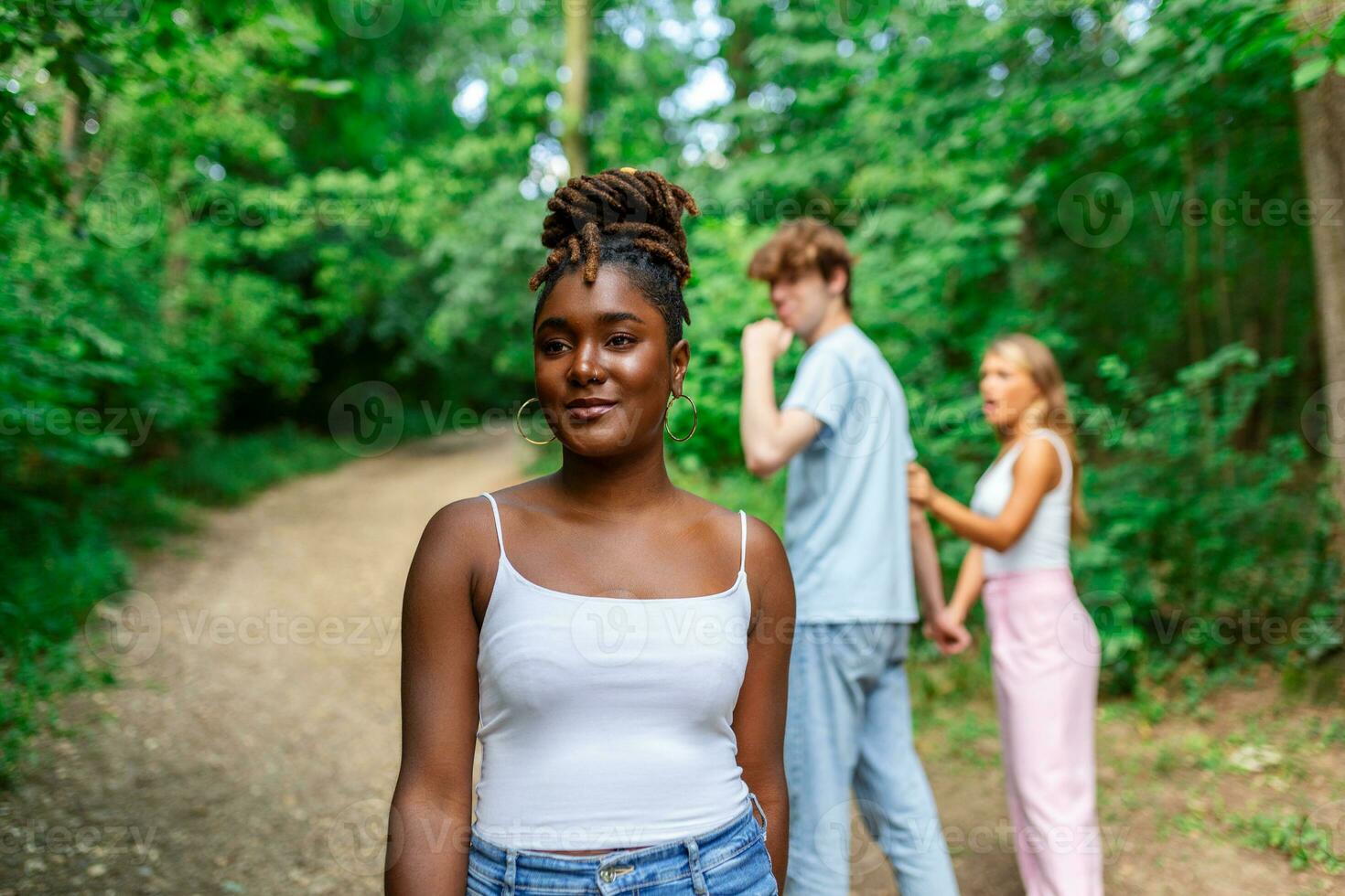Disloyal man walking with his girlfriend and looking amazed at another seductive girl photo