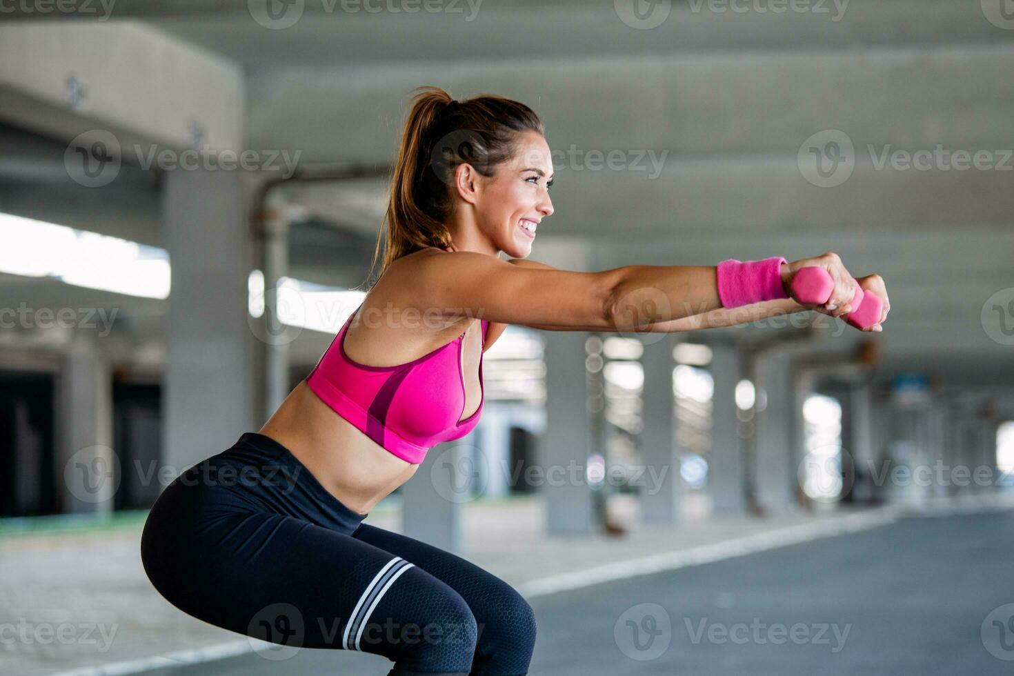 Sporty woman exercising with dumbbells. Photo of active woman in sportswear working out. Dynamic movement. Side view. Sport and healthy lifestyle