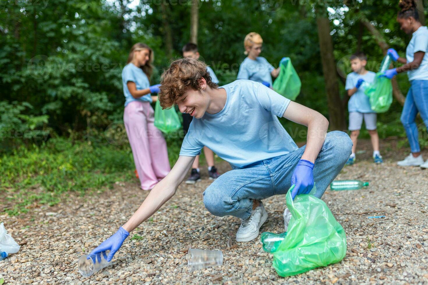 mano de hombre cosecha arriba botella dentro basura pantalones mientras limpieza zona en parque. trabajar como voluntario, caridad, gente, ecología concepto. de cerca voluntario coleccionar el plastico basura en bosque. mundo limpiar arriba metro día foto