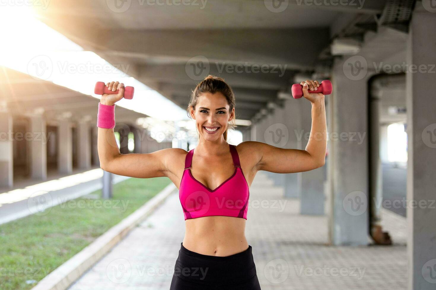 Strong fit woman working out with dumbbells. Attractive fit woman works out with dumbbells as a fitness conceptual. Active woman in sportswear working out. photo