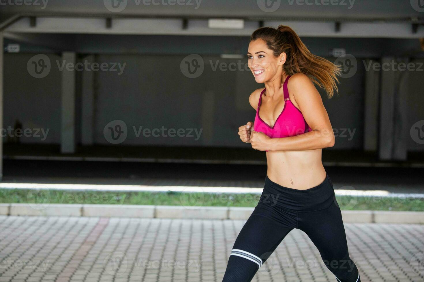 https://static.vecteezy.com/system/resources/previews/023/748/778/non_2x/young-woman-with-fit-body-jumping-and-running-against-grey-background-female-model-in-sportswear-exercising-outdoors-photo.jpg