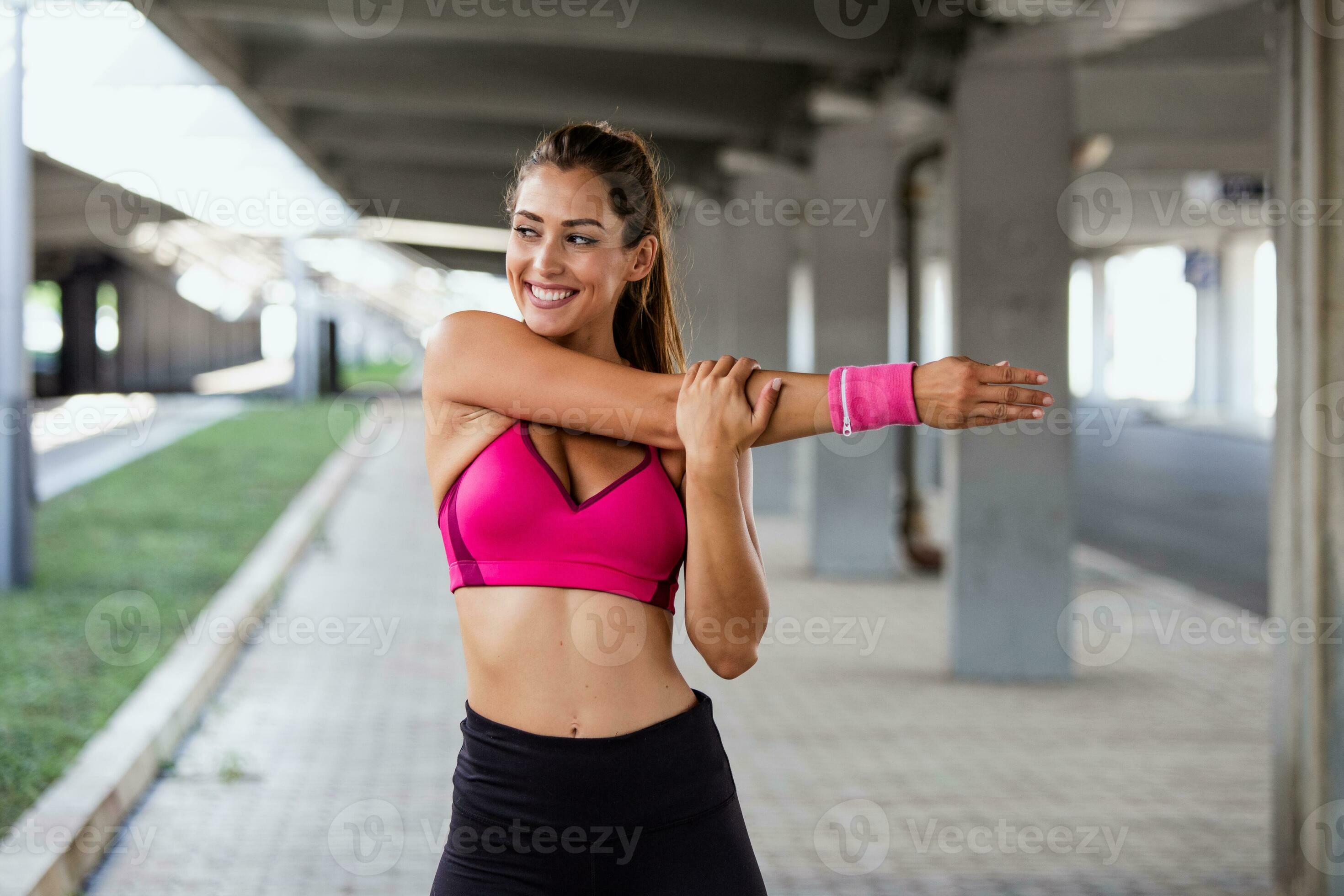 Young sporty woman training. Woman Doing Workout Exercises On Street.  Beautiful Athletic Fit Girl In Bright Sports Clothing Stretching Her Arm  And Relaxing After Fitness Training On Street. 23748780 Stock Photo at