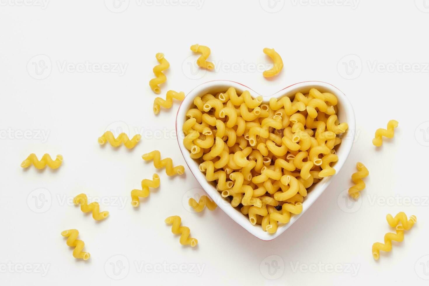 Raw pasta cavatappi in heart bowl. photo