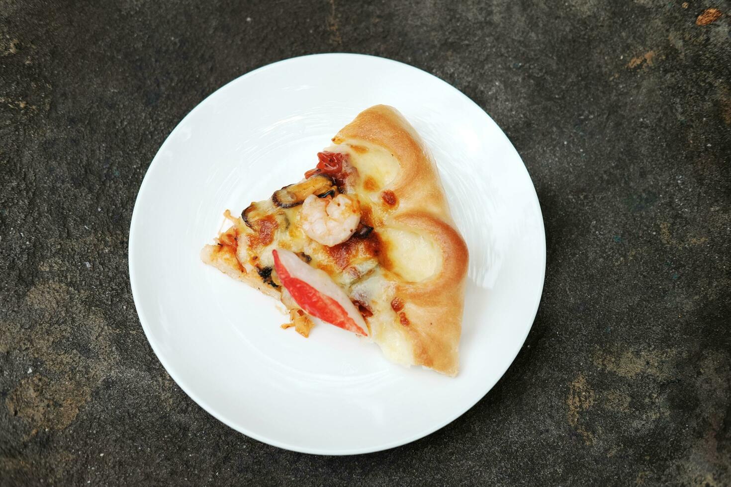 Delicious Italian food Sliced of Pizza on White dish and black concrete floor. photo