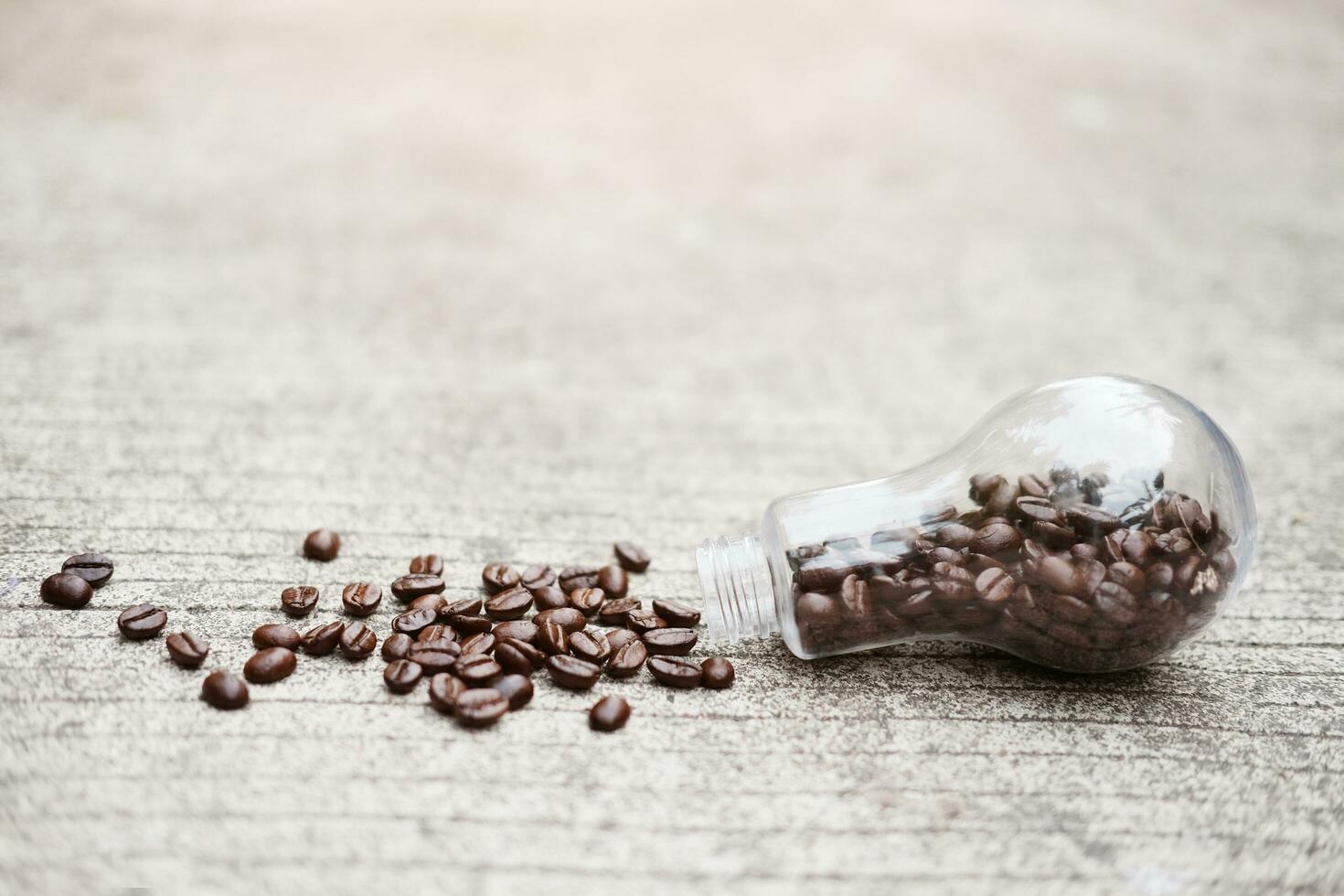 Coffee beans in glass vase on concrete floor with natural light morning in the garden. Caffeine drinks cause a fresh feeling. photo