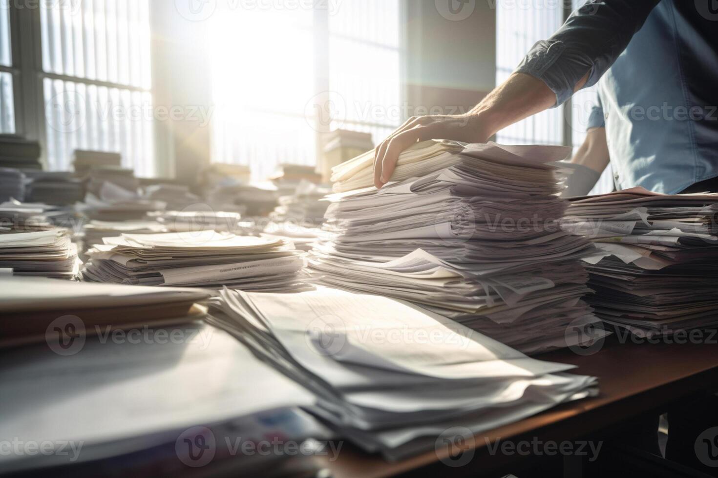 the hands of an office worker working with stacks of documents with photo