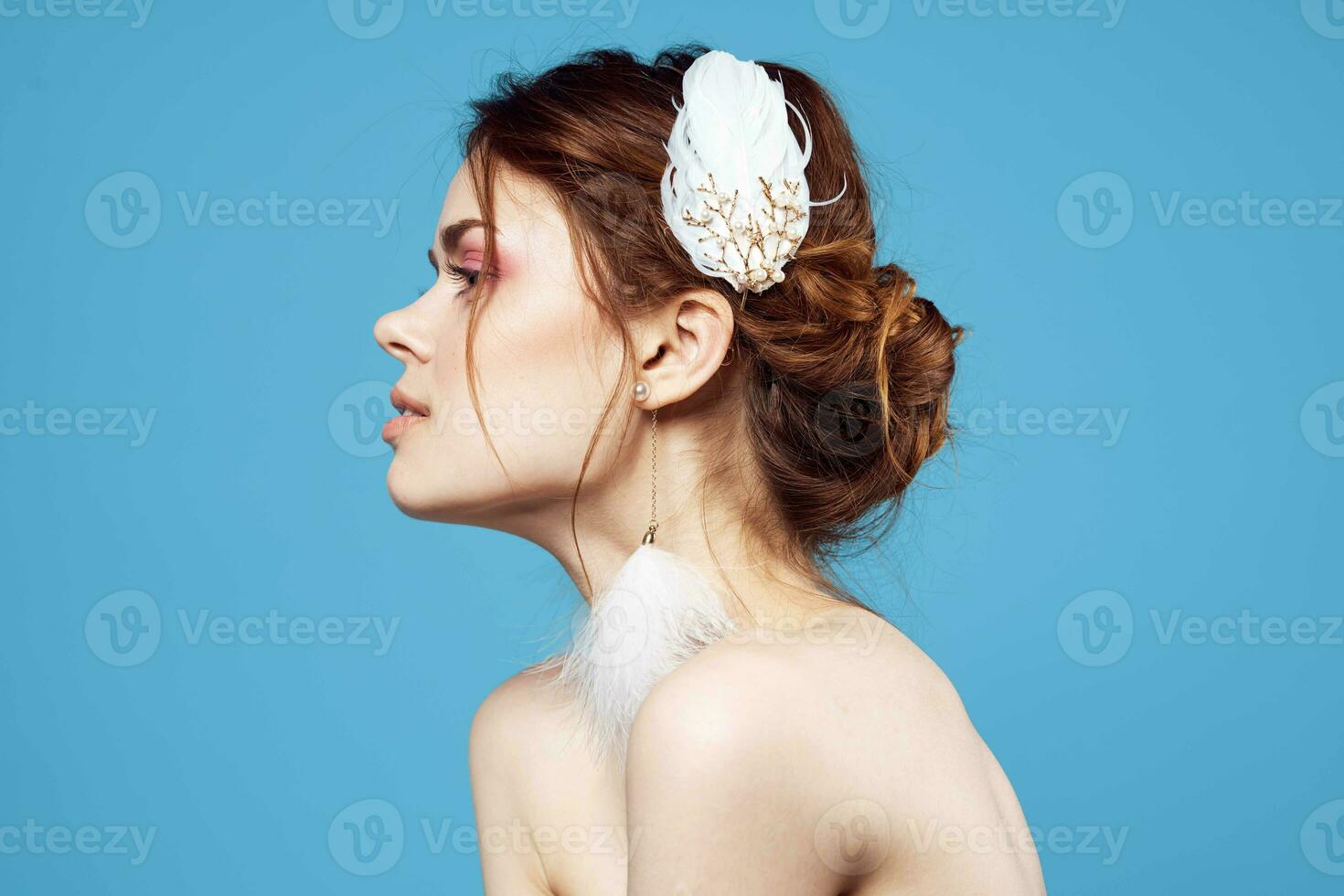 cheerful woman with bare shoulders bright makeup fluffy earrings blue background photo