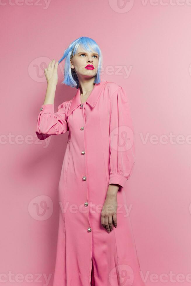 fashionable woman in blue wig pink dress red lips pink background photo