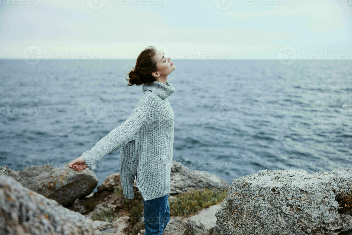 pretty woman beach tourism cloudy weather stone coast female relaxing back view photo