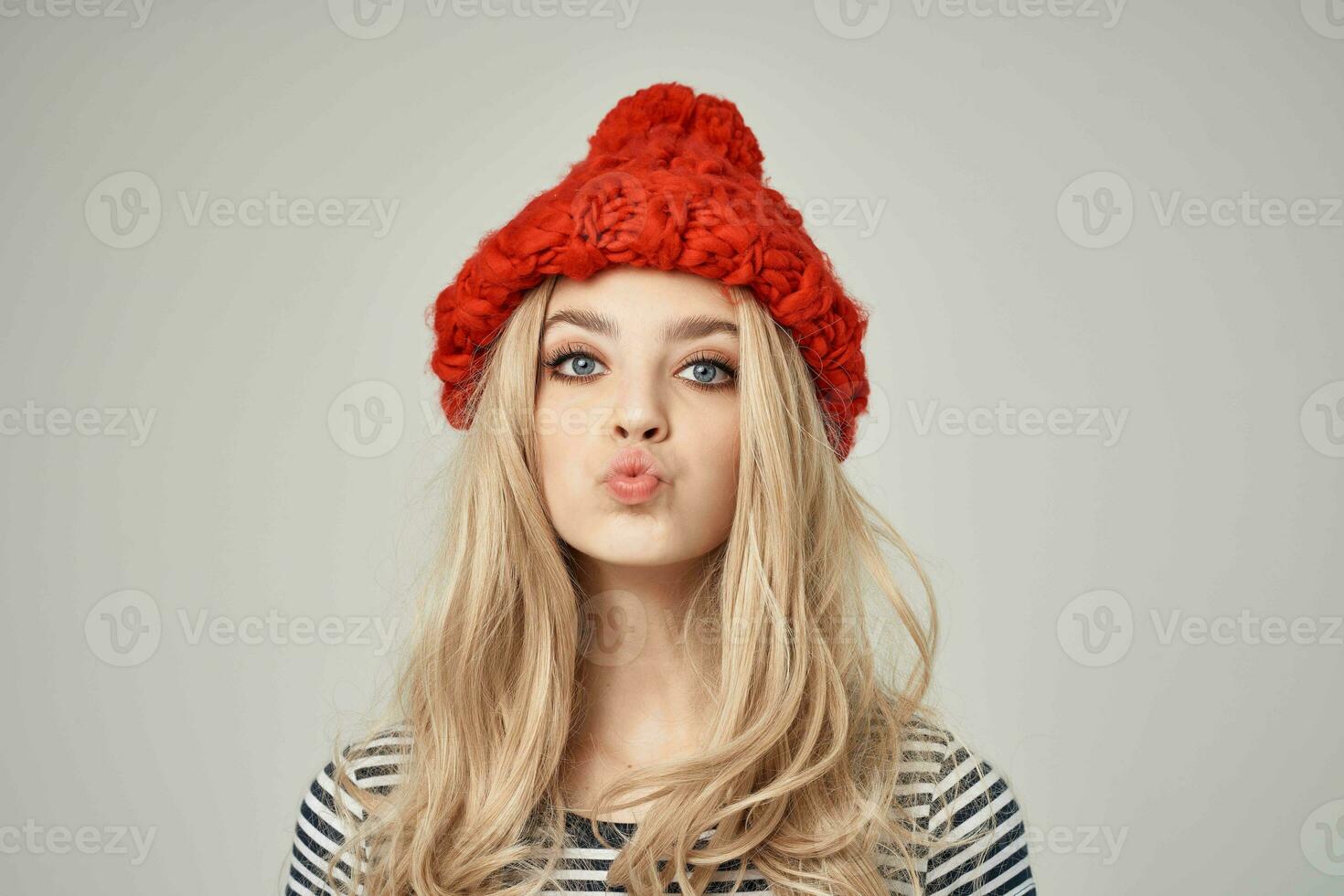 blonde in fashionable clothes Red Hat light background Lifestyle photo