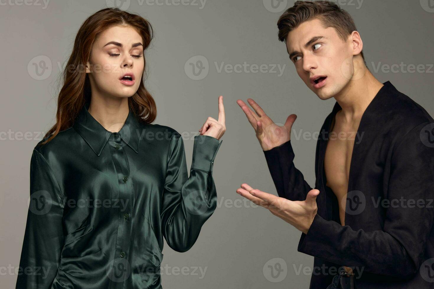 Conflict situation young people in suits on a gray background are gesturing with their hands photo