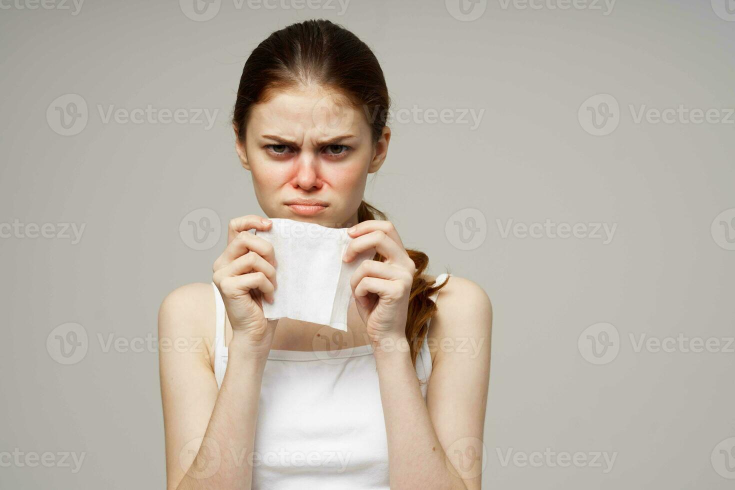 sick woman in white t-shirt with a scarf light background photo