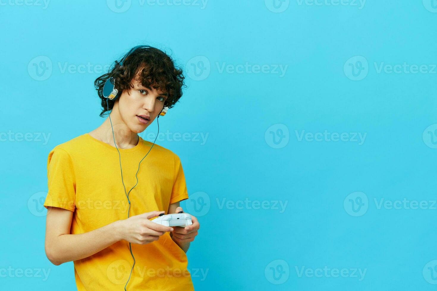 man yellow T-shirt with joystick video games blue background photo