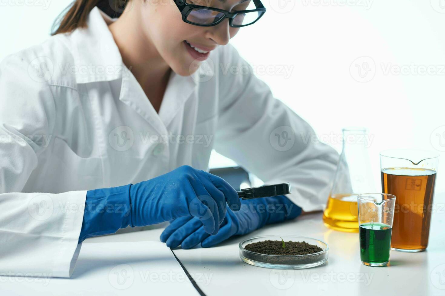 female laboratory assistant looking through a magnifier biology follow-up chemical solution photo