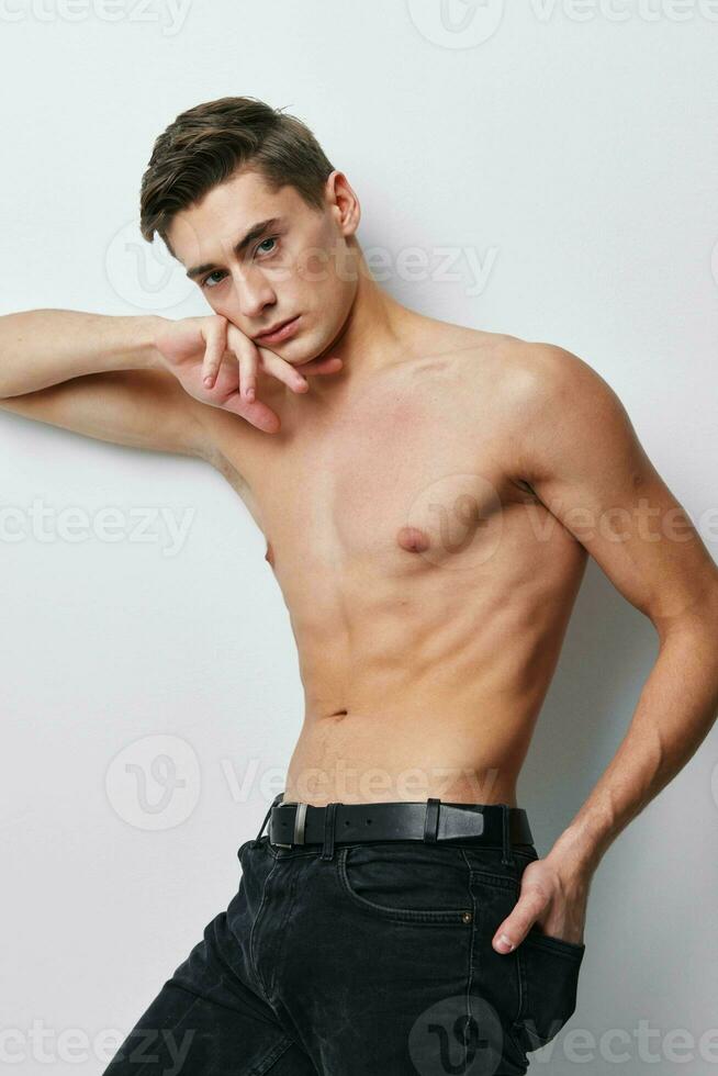 Man holds his hand behind his head naked torso sports figure model photo