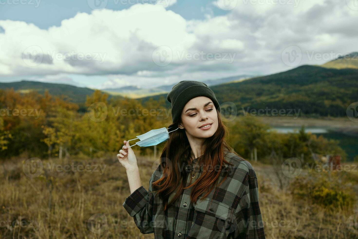 Beautiful woman with medical mask in the autumn forest in nature photo