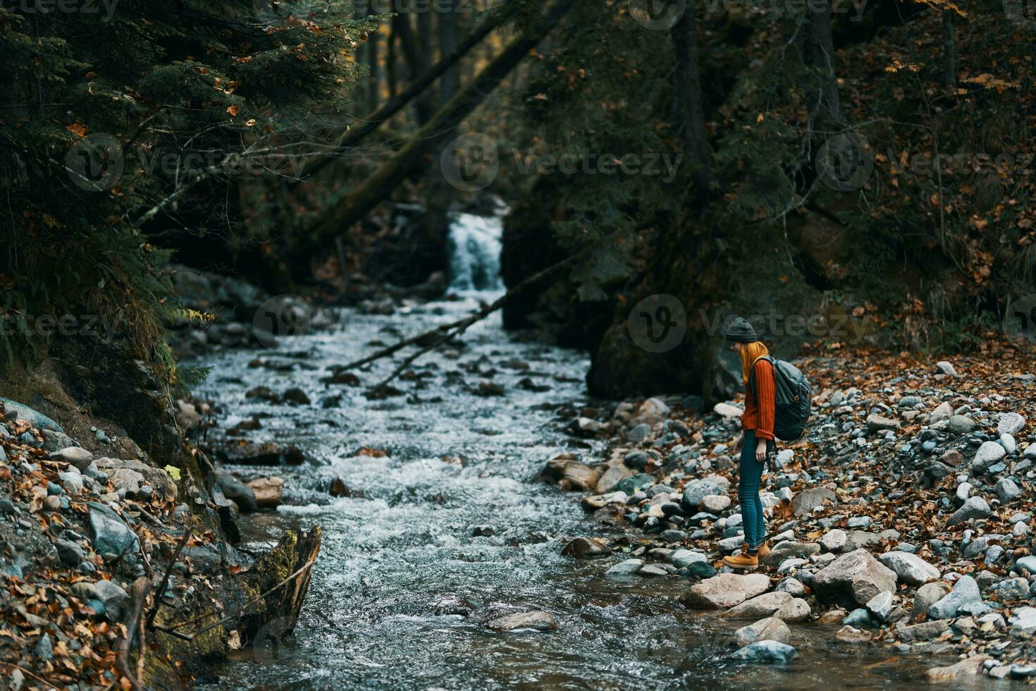 traveler with backpack landscape mountains transparent river pond and forest in the background photo