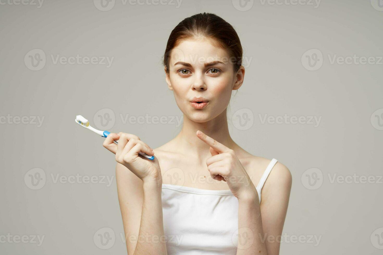 cheerful woman toothpaste brushing teeth dental health light background photo