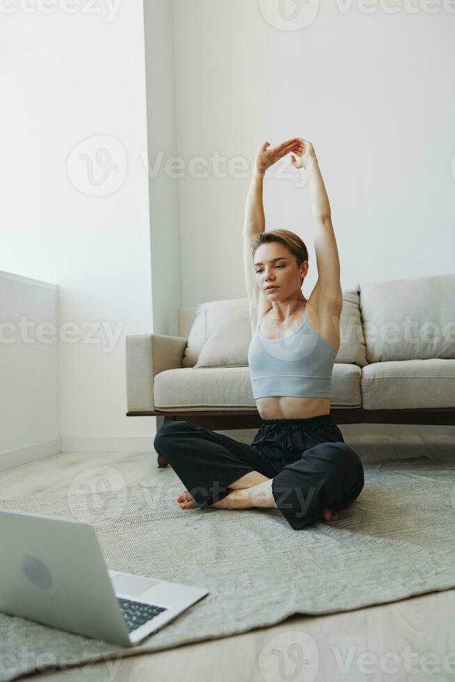 mujer hacer ejercicio a hogar por vídeo rutina de ejercicio en línea, meditación y extensión, mental salud foto