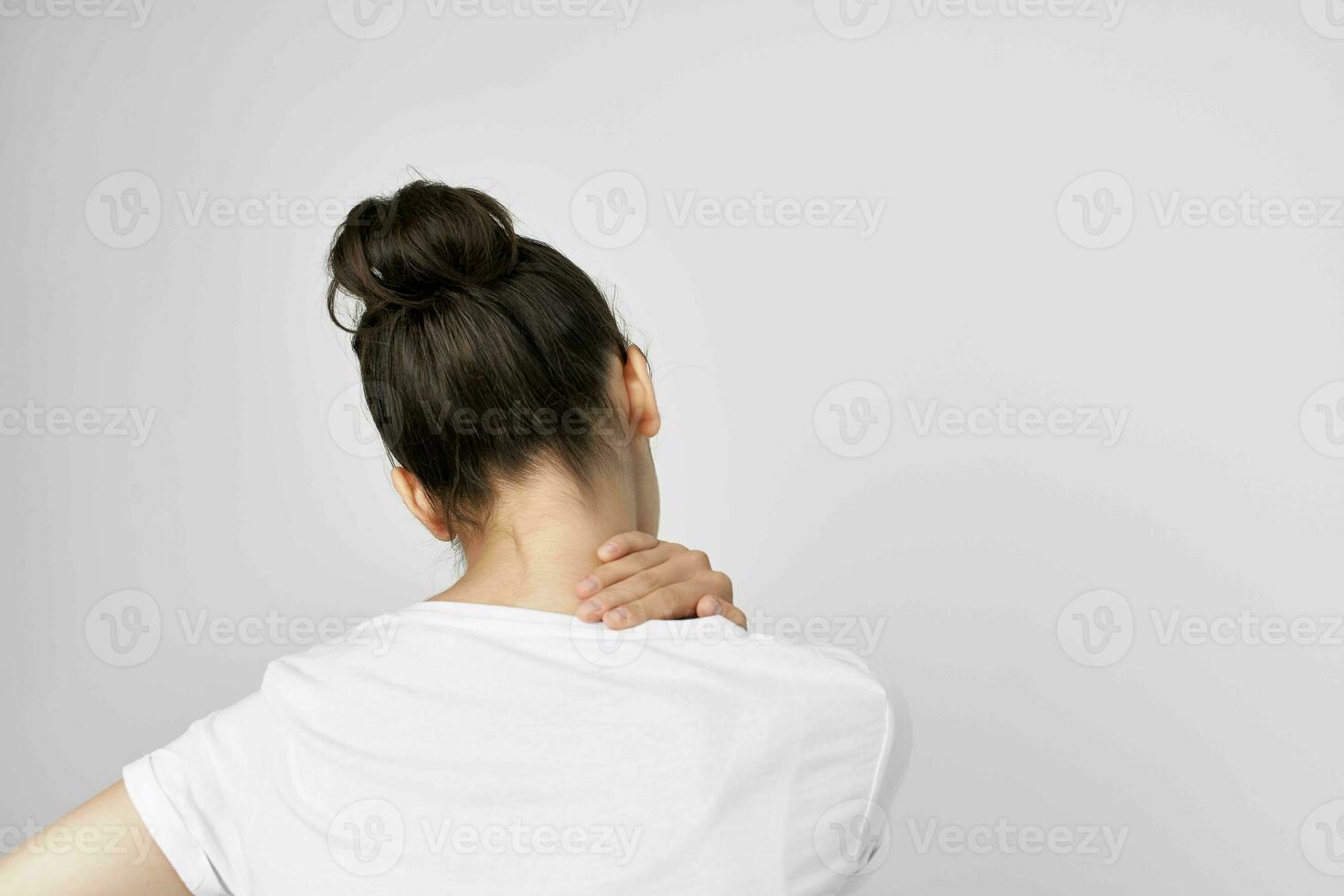 brunette in a white t-shirt pain in the neck isolated background photo