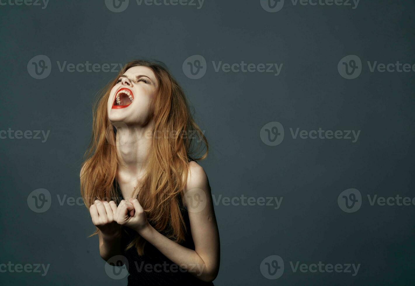 impulsive woman on a gray background indignant Look model and black dress 23757568 Stock Photo