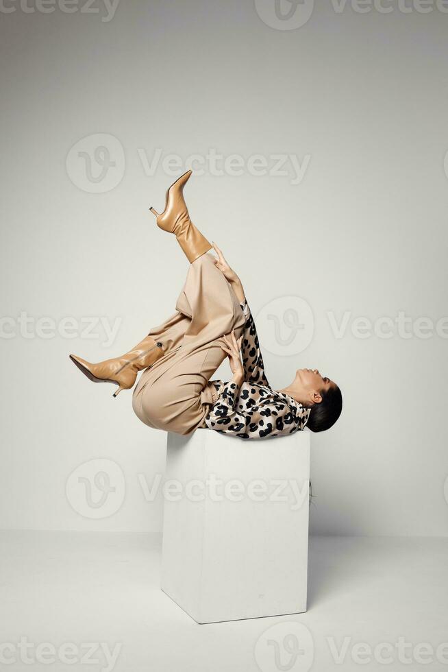 woman lying upside down fashionable clothes brown boots photo