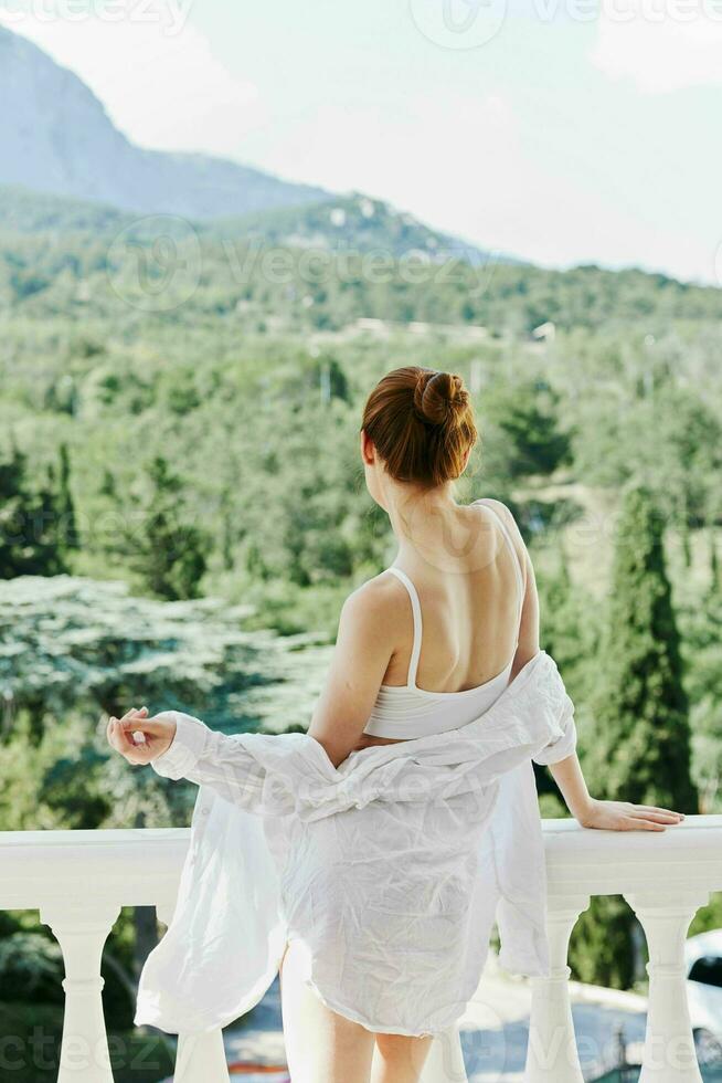 Portrait of a beautiful woman in sexy lingerie posing on balcony sunny day photo