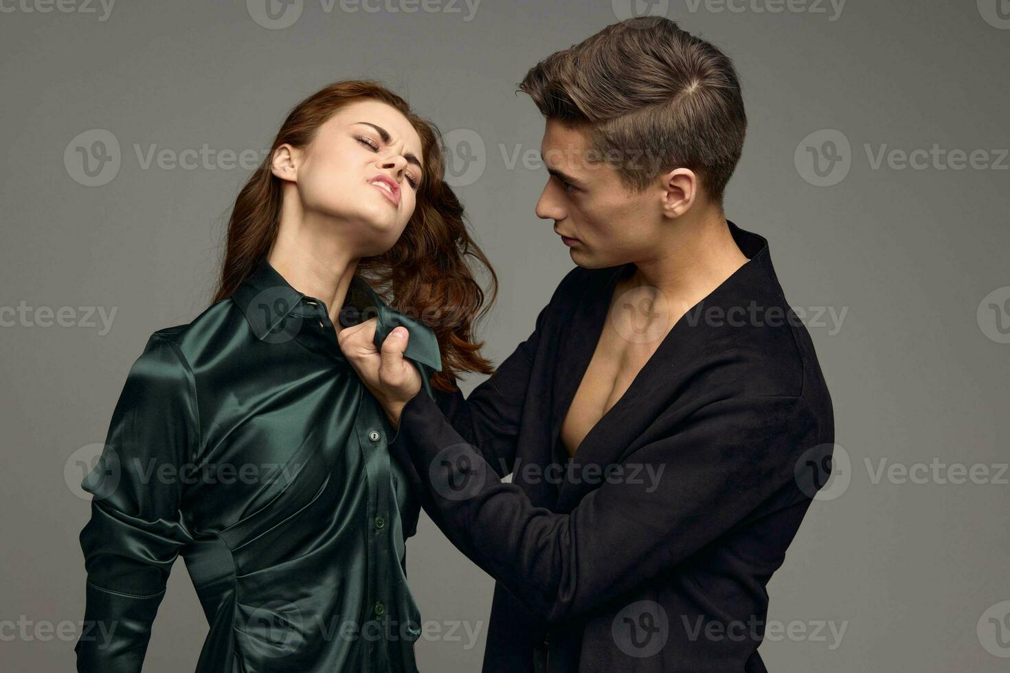 A man in a suit hurts a beautiful woman in a dress photo
