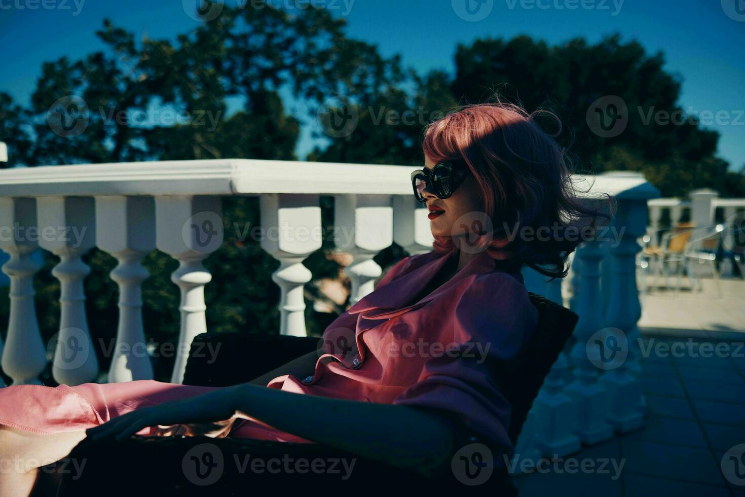 glamorous woman in sunglasses outdoors sitting on the terrace relaxing sunny day photo